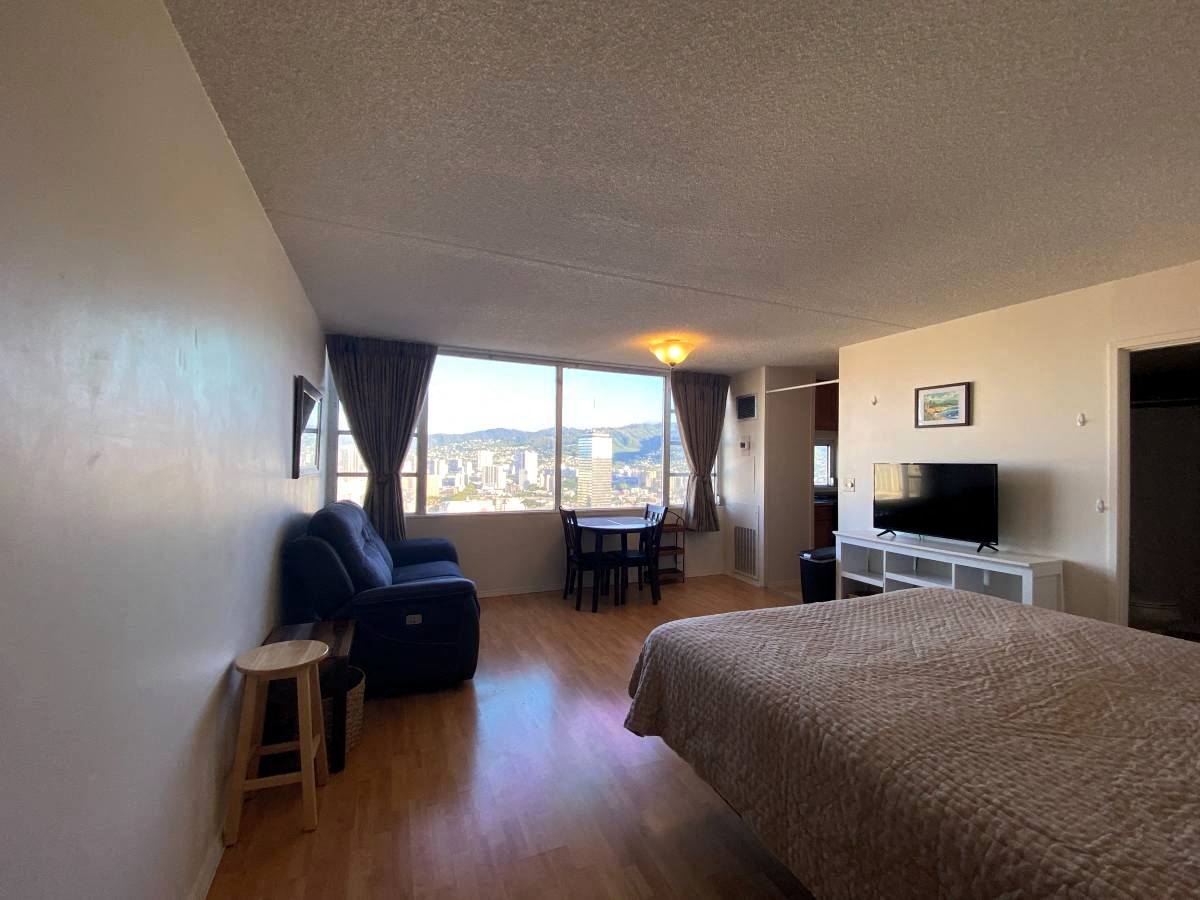 A bedroom with a large bed and a flat screen TV.